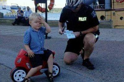 Young child getting ticket on toy car Funny